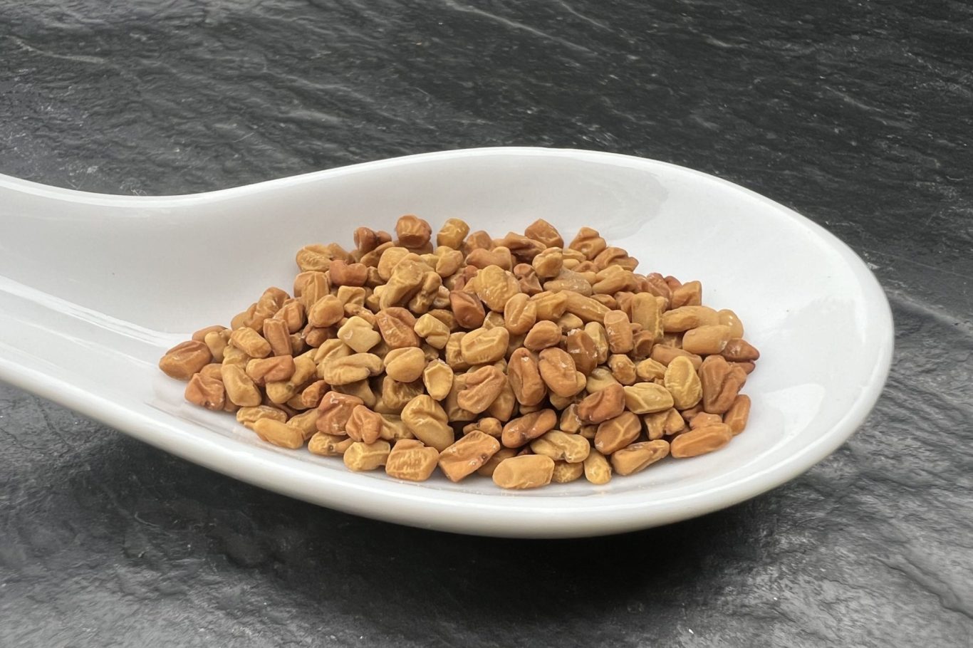 Bockshornklee Ein Löffel mit einem Haufen Bockshornklee.